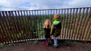 Kindvriendelijke wandeling Landgoed Schovenhorst Landgoed Schovenhorst: hét mooiste geheim van Putten Landgoed Schovenhorst: wandel en natuurplezier Landgoed Schovenhorst is dé ideale plek voor een middagje wandel en natuurplezier. Combineer een fijne wandeling door het Landgoed met een bezoek aan de Bostoren Putten. Je moet geen hoogtevrees hebben om deze 325 traptreden te bedwingen. Maar je wordt hoogtevrees wordt beloond: éénmaal boven geniet je van een gaaf uitzicht en kun je bij helder weer zelfs Amersfoort zien! Onderweg naar boven kun je nestkastjes bewonderen en de echte durfal loopt over het wandelnet heen. Maar kijk niet naar beneden, want dan kan het toch gaan kriebelen. Mooiste geheim van Putten Wist je dat Landgoed Schovenhorst het mooiste geheim van Putten wordt genoemd? Wij begrijpen het wel. Een magnifiek uitzicht vanaf de Bostoren geeft je al een goede reden waarom dit zo’n mooi bewaard geheim is. Diverse kindvriendelijke wandelingen De wandelingen die je hier kunt maken beginnen al vanaf 2,5 km. Zo is er de Bomentuinwandeling van 2,5 km via een groene markering aangegeven. Of kies voor de Boswandeling van 4 km, aangegeven door een gele markering. Tijdens deze route ontdek je de verscheidenheid aan bomen op het landgoed.  Heb je oudere kinderen of wellicht zeer sportieve kids? Kies dan voor de Cultuurhistorische route van 8 km, met rode markeringen aangegeven. Deze route neemt je mee op een reis door de tijd. Dit landgoed kent namelijk een prachtig verleden. Speelbos Landgoed Schovenhorst Uitgewandeld? Breng dan ook nog een bezoek aan het speelbos. Hutten bouwen, ravotten en klauteren: het kan allemaal in het Speelbos. In dit deel van het bos is een bostheater, een grote zandbak, er zijn klauternetten en omgevallen bomen en stronken om hutten mee te bouwen. Kinderen zijn de baas op dit deel van het Landgoed dat speciaal voor hen is ingericht. Uiteraard zijn er genoeg plekken onderweg om even te stoppen en te genieten van het uitzicht. Neem wat lekkers te eten en te drinken mee voor onderweg en maak er een heerlijke picknick van. Of kies voor wat lekkers bij Brasserie Schovenhorst.  De keus is aan jou. Brasserie Schovenhorst Uitgewandeld en geklommen? Ga dan nog een lekker hapje en drankje doen bij Brasserie Schovenhorst. Heerlijk eten en drinken! Bij het buitenterras is er ook nog een fijne speelgelegenheid voor kids. Ideaal!  Meer informatie over Landgoed Schovenhorst vind je hier: Website: www.schovenhorst.nl: Tel: 0341- 351 207 Kinderen genieten van uitzicht Bostoren Putten