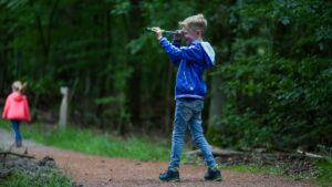 Jongen met verrekijker in Park Hoge Veluwe zomerspeurtocht