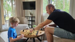 Gezin speelt spelletje in vakantiewoning
